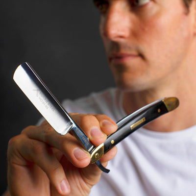 Man holding the Naked Armor Solomon Straight Razor 7/8" Black Algum Wood Japanese Steel