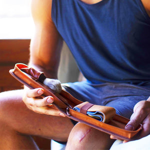 Man storing his shaving essentials inside the Naked Armor Cador Leather Travel Case