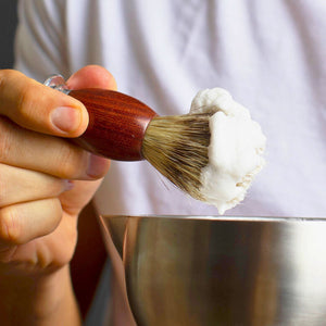 Man creating a rich lather using the Naked Armor Sandalwood Shaving Brush and Silver Fox Scuttle