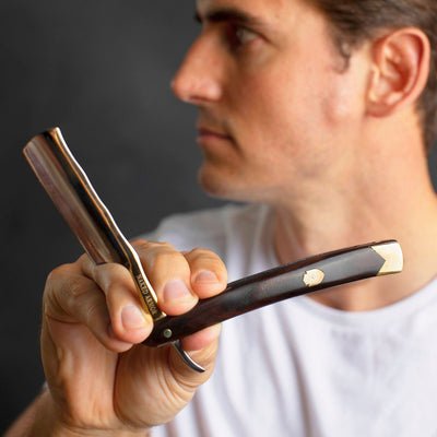 Man holding the Naked Armor King Arthur Gold Straight Razor 7/8" Ebony Japanese Stainless Steel