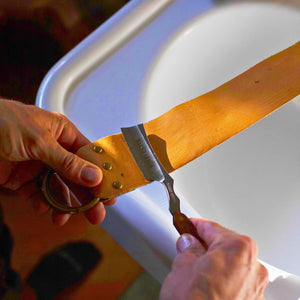 Man stropping the Naked Armor Thor Straight Razor 7/8" Redwood Japanese Stainless Steel on the Blue Eel Strop