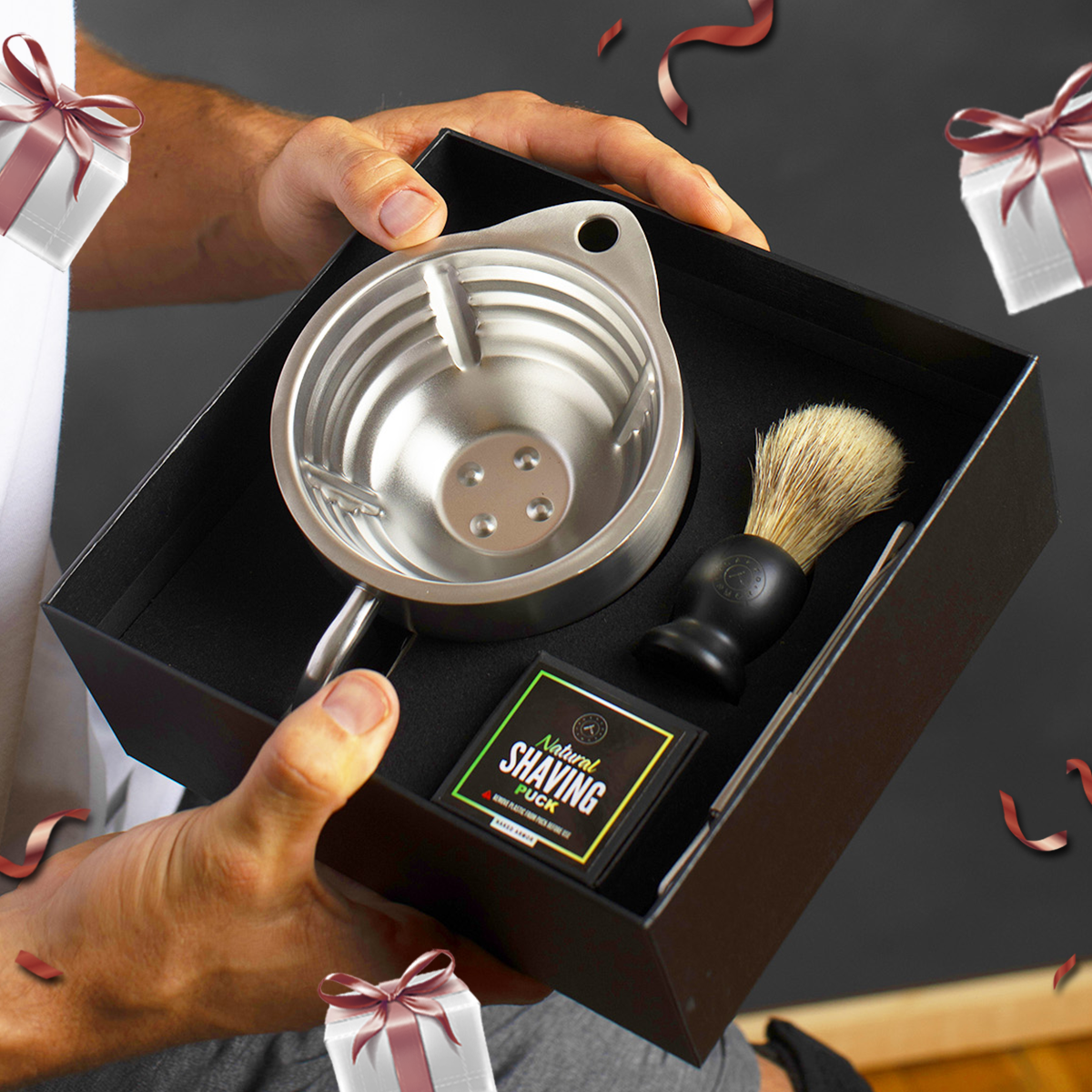 A man holding the Naked Armor Silver Fox Scuttle Kit urrounded by Mother's Day themed gift boxes and confetti.