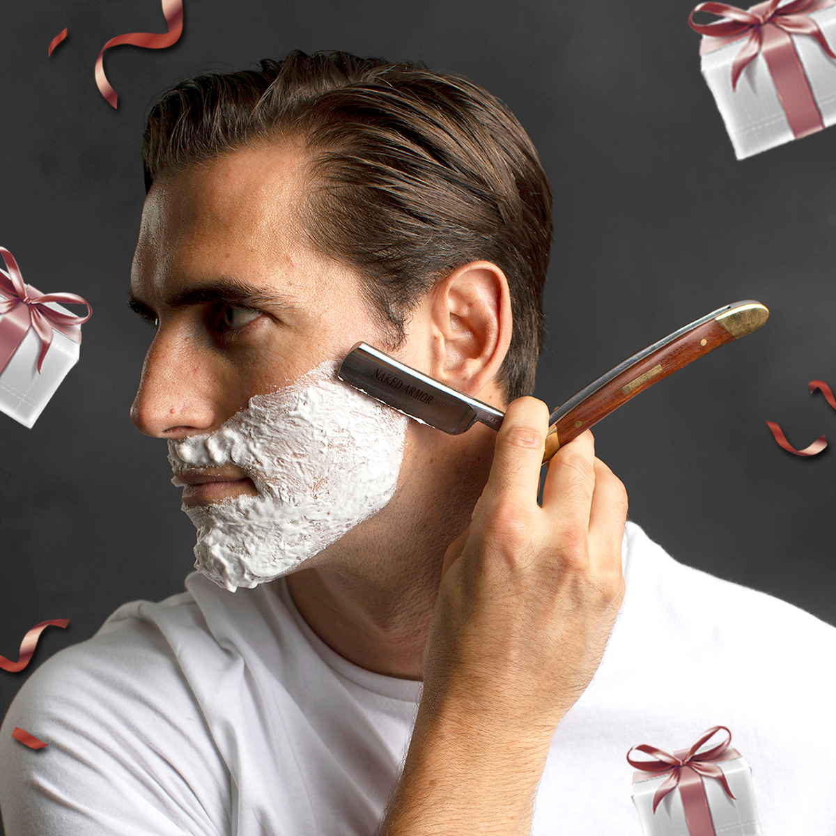 A man shaving with the Naked Armor Solomon Straight Razor surrounded by Mother's Day themed gift boxes and confetti.